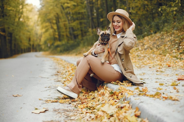 Vrouw en hond spelen en hebben plezier in het herfstpark