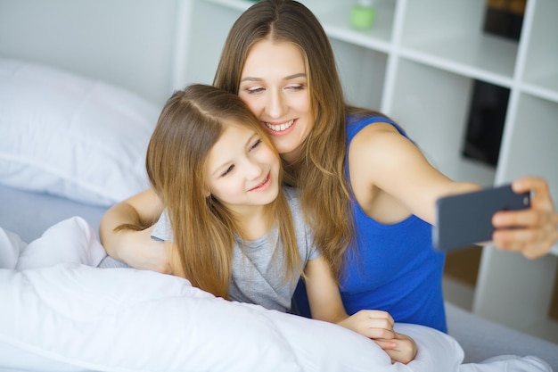 Vrouw en jong meisje liggend in bed glimlachend