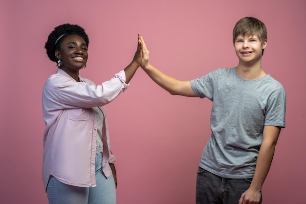 Vrouw en jongen aanraken met handpalmen kijken naar camera