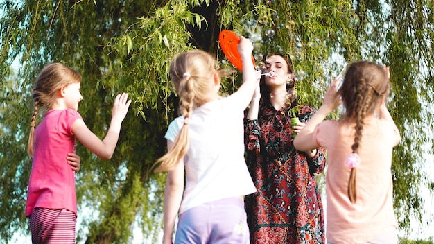 Vrouw en kinderen spelen met zeepballonnen