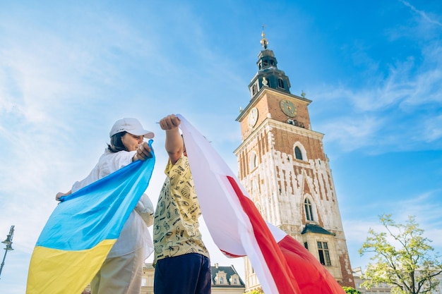 Vrouw en kleine jongen bedekt met de vlag van Oekraïne en Polen in het stadscentrum