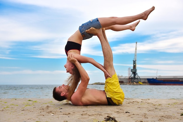Vrouw en man die acrobatische yoga doen