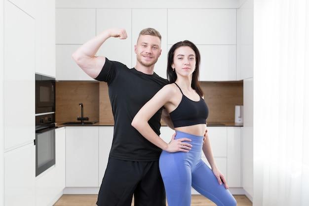 Vrouw en man die zich voordeed op camera, twee fitness atleten in de keuken thuis