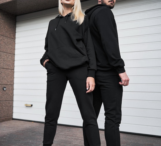 Vrouw en man dragen zwarte hoodie zonder logo Geen logo basic sportkleding Sweatshirt met lange mouwen