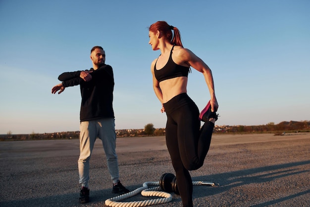 Vrouw en man hebben 's avonds samen fitnessdag op de weg