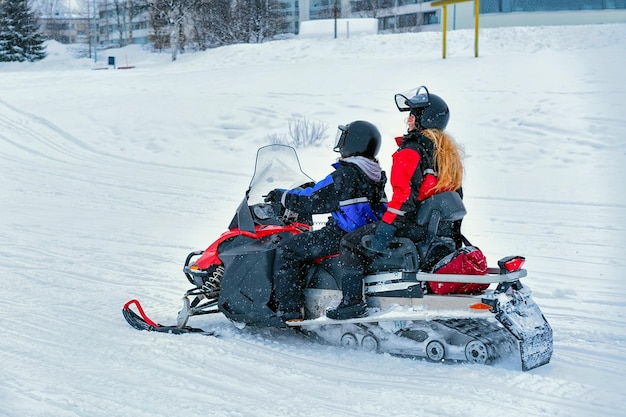 Vrouw en man op sneeuwscooter in Winter Finland, Lapland met Kerstmis. Extreme sportactiviteit en recreatie in het koude seizoen.