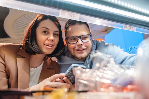 Vrouw en man op zoek naar producten op plank Koppel klanten winkelen met checklist