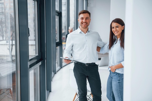 Vrouw en man praten over documenten voor een jong succesvol team dat binnenshuis op kantoor samenwerkt en communiceert
