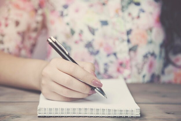 Vrouw en notitieblok op houten tafel