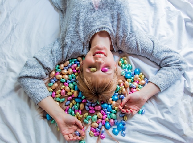Vrouw en Pasen-snoep in een bed