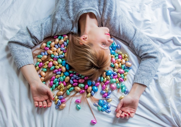 Foto vrouw en pasen-snoep in een bed