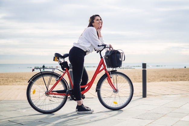 Vrouw fietsten langs strandzand in de zomer. Gezond en sportconcept