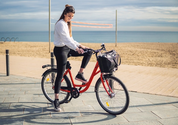 Vrouw fietsten langs strandzand in de zomer. Gezond en sportconcept