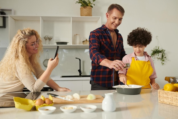 Vrouw filmt koken man en zoon