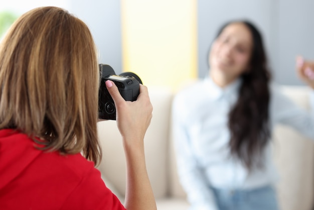 Vrouw fotograaf fotografeert model op bank close-up