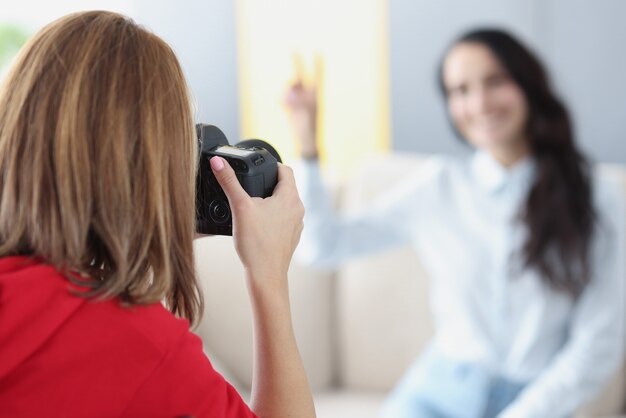 Vrouw fotograaf maakt foto's van meisje op de bank