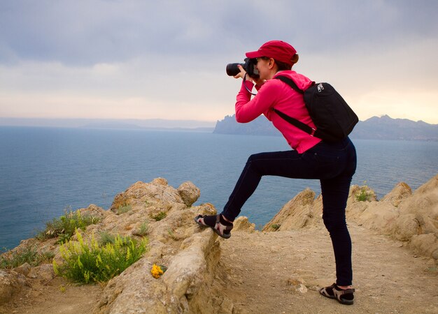 Vrouw fotograaf op de top van de berg en fotograferen landschap.