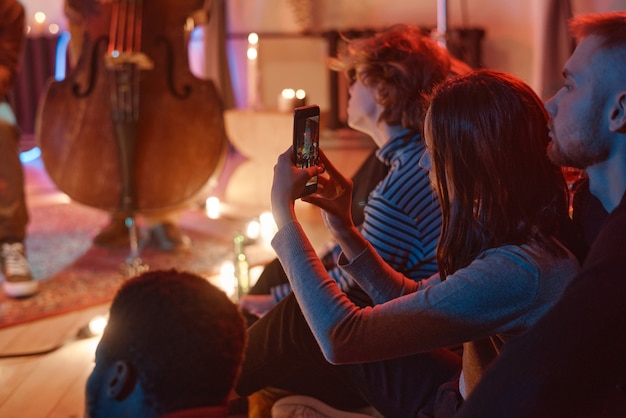 Vrouw fotografeert de voorstelling aan de telefoon