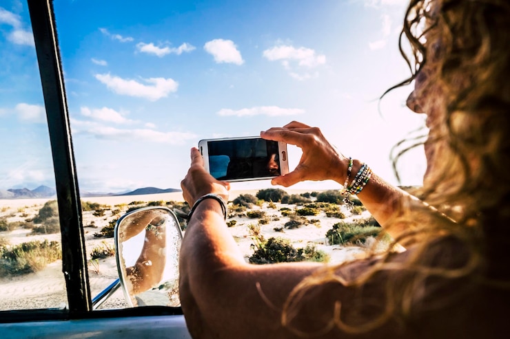 Foto vrouw fotografeert met een smartphone tegen de lucht