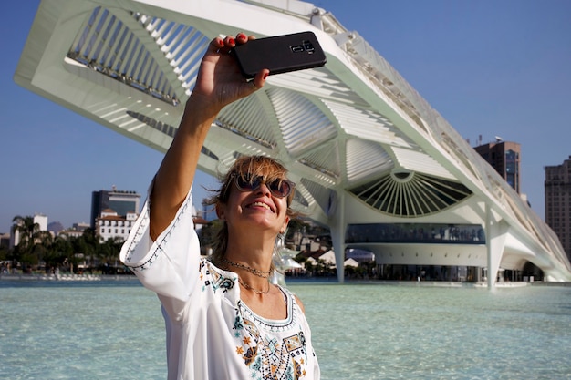 Vrouw fotograferen en filmen met de mobiele telefoon op het plein MauÃ in Rio de Janeiro