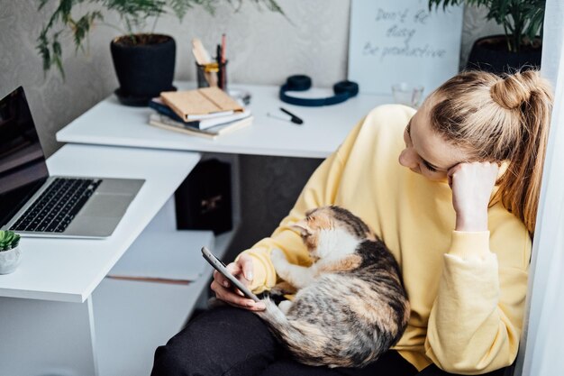 Foto vrouw freelance of uitstel op de werkplek thuis kantoor zelfstandige zakenvrouw met kat