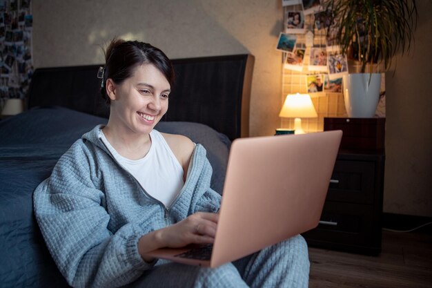 Vrouw freelancer thuis werken op laptop zittend op de vloer laptop knieën