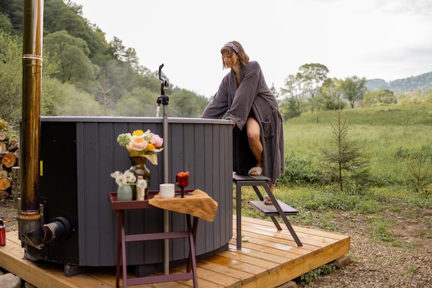 Vrouw gaat baden in een hot tub in de natuur.