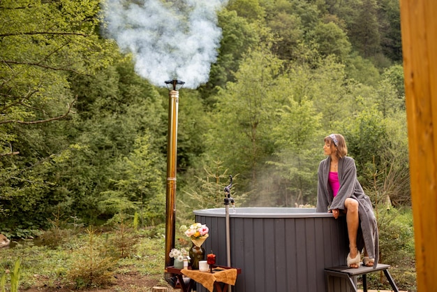 Vrouw gaat baden in een hot tub in de natuur.