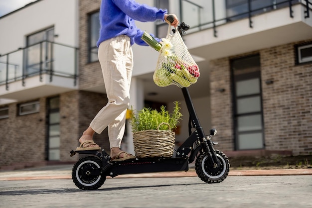 Vrouw gaat naar huis met verse groenten op elektrische scooter