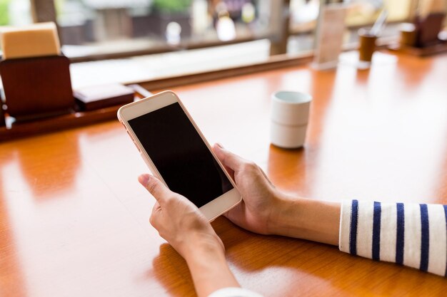 Vrouw gebruik van mobiele telefoon in restaurant