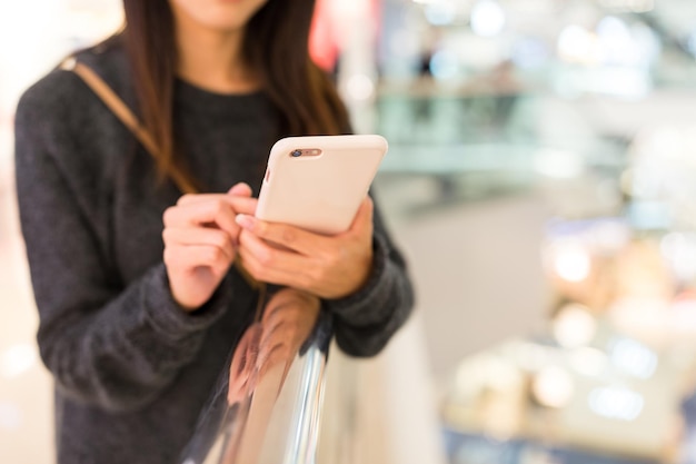 Vrouw gebruik van mobiele telefoon in winkelcentrum