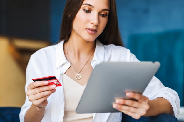 Vrouw gebruikt bankkaart om te betalen voor online gekochte goederen.