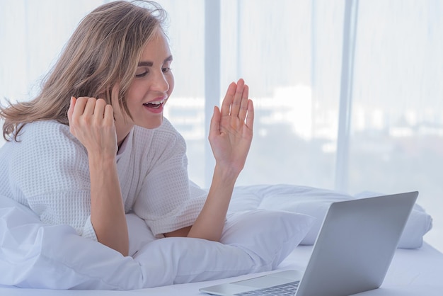 Vrouw gebruikt computernotitieboekje op bed meisje videogesprek met vriend of familie