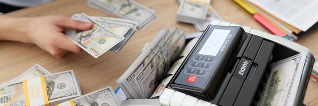 Vrouw gebruikt de rekeningteller om geld contant te tellen nadat ze een winstgevende deal heeft gemaakt waar de accountant bij zit