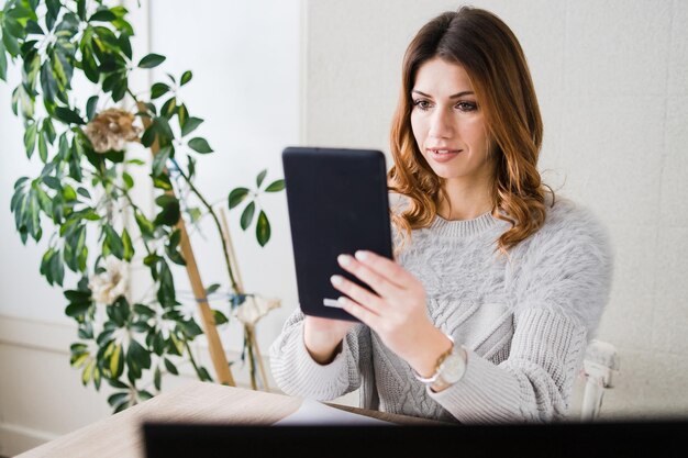 Vrouw gebruikt digitale tablet terwijl ze thuis zit