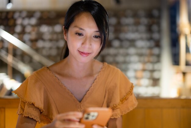 Vrouw gebruikt mobiele telefoon in een koffieshop