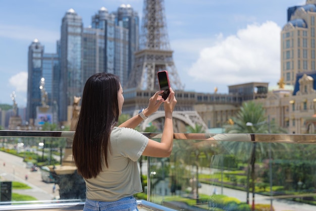 Vrouw gebruikt mobiele telefoon om foto's te maken van het centrum van Macau
