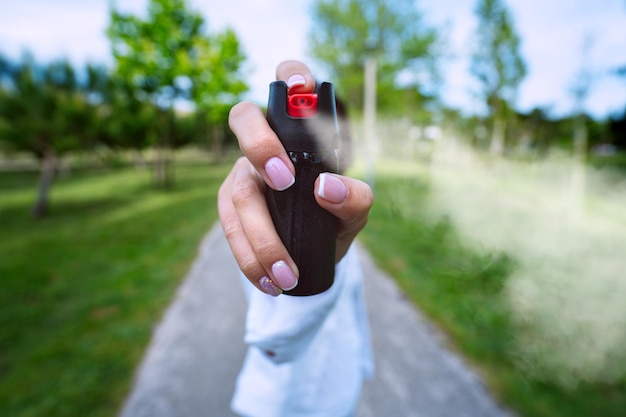 Foto vrouw gebruikt pepperspray of traangas voor zelfverdediging buitenshuis