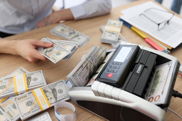 Vrouw gebruikt rekeningenteller om geld contant te tellen nadat ze een winstgevende deal heeft gesloten waar de accountant bij zit
