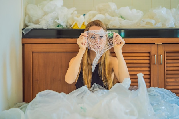 Vrouw gebruikte te veel plastic zakken waardoor ze de hele keuken vulden Zero waste concept Het concept van Wereldmilieudag