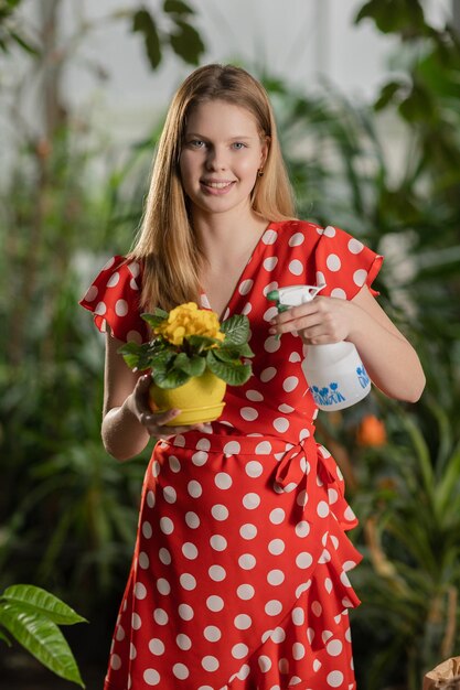 Vrouw geeft gele bloemen water in de pot Slowmotion video van een meisje dat thuis tuiniert, vrouw i