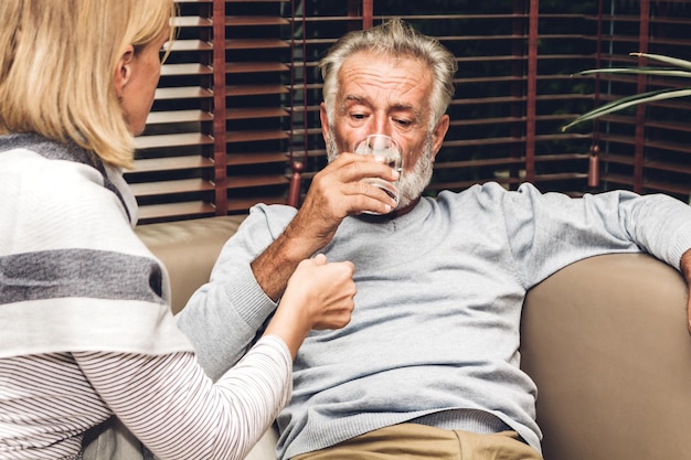 Vrouw geeft medicijnen aan man thuis