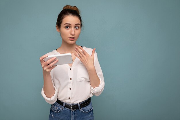 vrouw, gekleed in casual wit overhemd en geïsoleerd op blauwe achtergrond