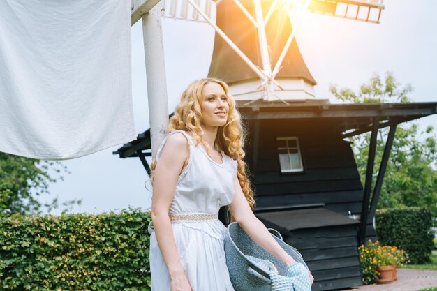 Foto vrouw gekleed in een traditionele nederlandse jurk die kleding aan een waslijn buiten hangt