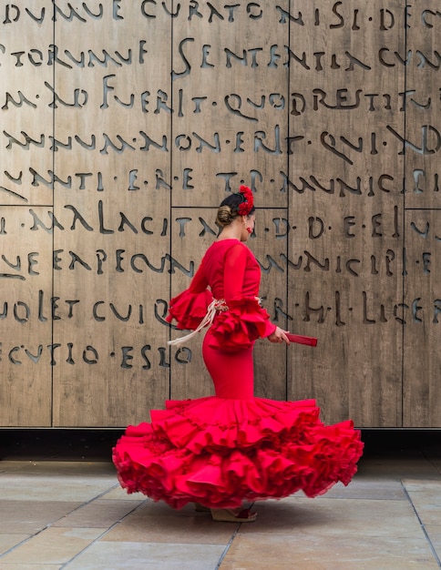 Foto vrouw gekleed in rode dansende flamenco met rode waaier