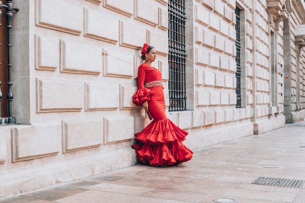 Vrouw gekleed in rode dansende flamenco met rode waaier