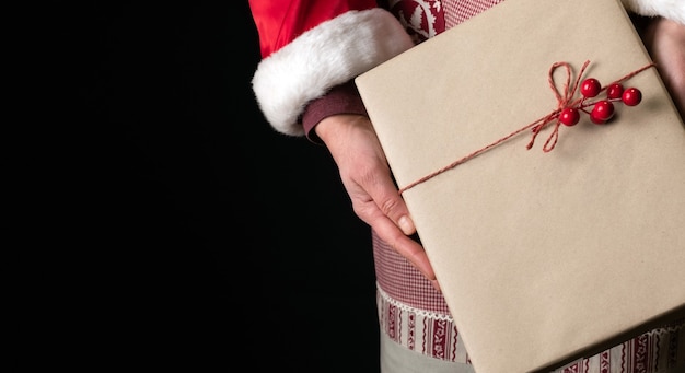 Vrouw gekleed in rode feestelijke schort met Gift's Box aan de vooravond van Nieuwjaar.