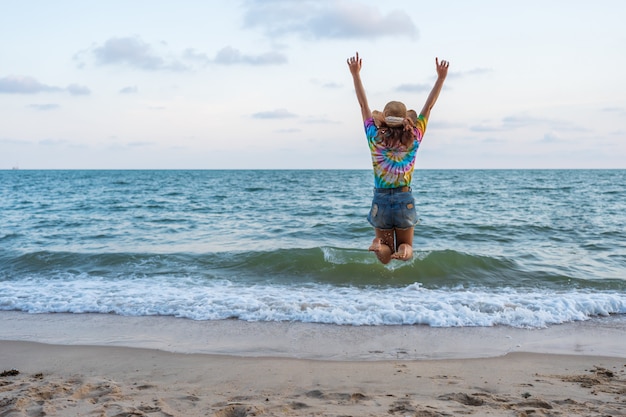 Vrouw geniet en springen op zee strand