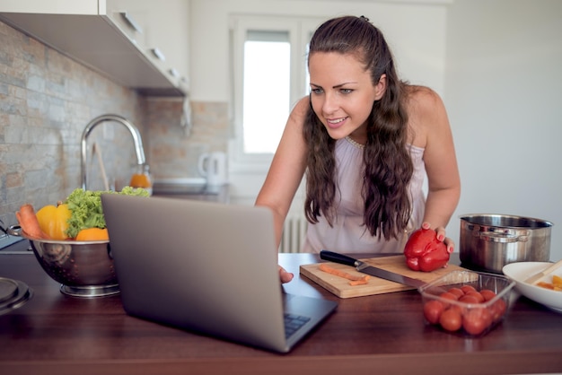 Vrouw geniet ervan om in de keuken te koken