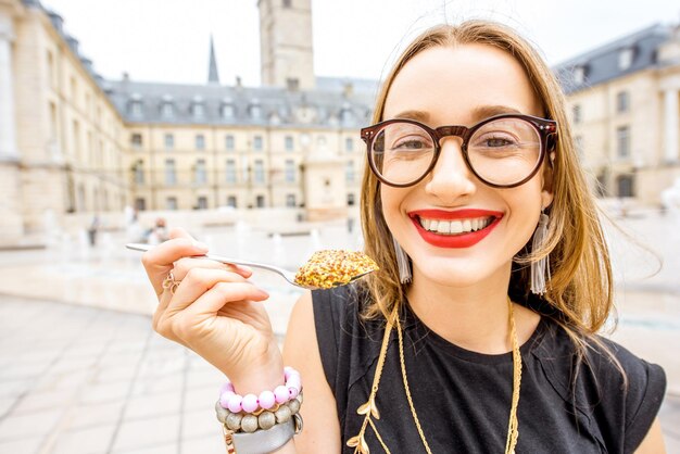 Vrouw geniet van beroemde dijon-mosterd die buiten op het centrale plein in de stad dijon in frankrijk staat